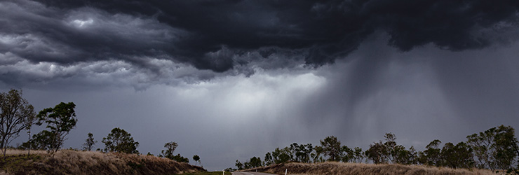 Dark and stormy clouds over a bush landscape