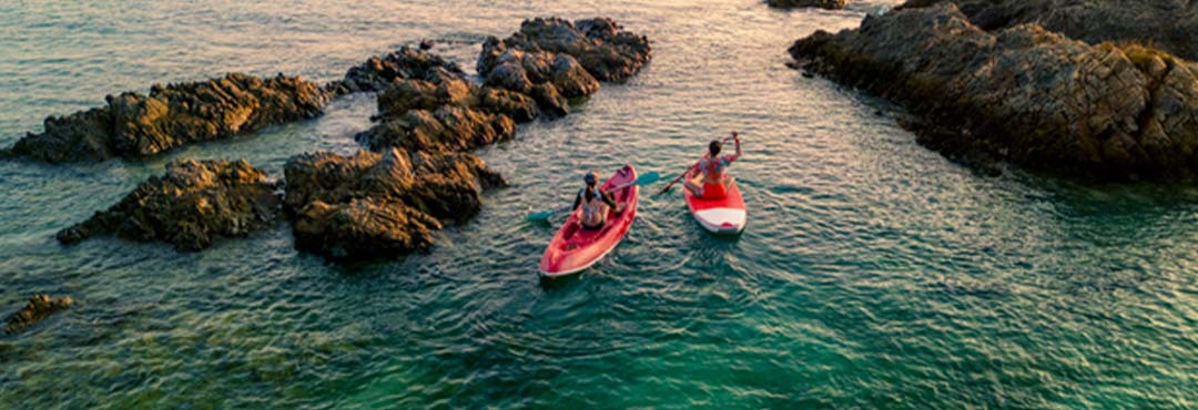 People in kayaks padding in crystal blue water