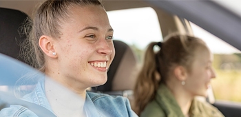 Two young women driving a car