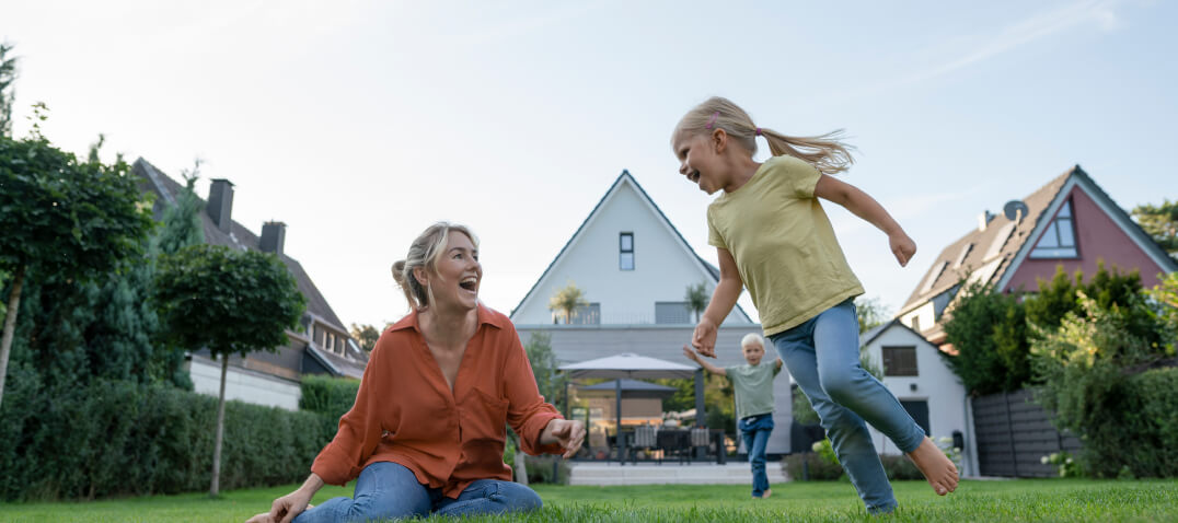 A family playing in the back garden of their home.]